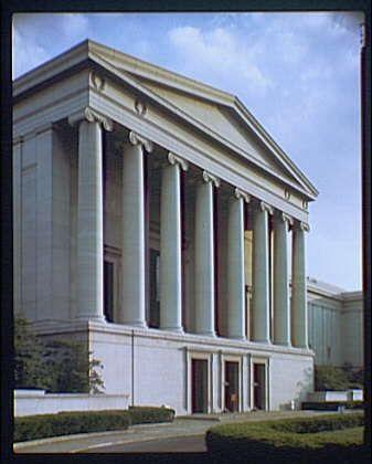 The image shows the exterior of a large neoclassical building with tall columns and a symmetrical facade. The structure is primarily white, with decorative trim around the windows and doors. It appears to be an official or governmental institution, possibly located on Constitution Avenue as mentioned in the caption. The sky behind the building is clear, indicating fair weather conditions at the time of photographing. This image was taken by Theodore Horydczak (approximately 1890-1971), and it measures approximately eight inches wide by ten inches tall with a transparency medium format.