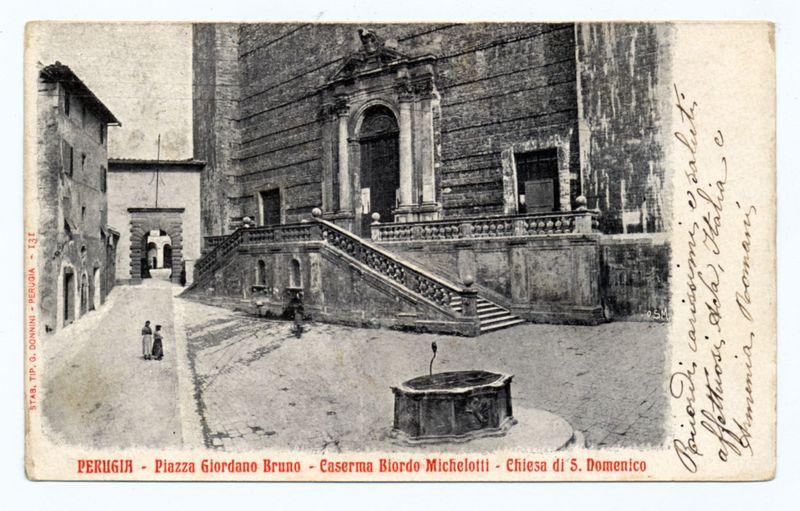 The image depicts an old photograph of the Piazza Giordano Bruno in Perugia, featuring architectural elements such as a grand staircase leading to what appears to be Caserma Biordo Michelotti. The structure has classical columns and decorative balustrades on its upper level, suggesting historical significance or public importance.

In the foreground, there's an old-fashioned well with a metal tap located near it. Two individuals are visible in the scene; one is standing by the staircase, possibly observing something out of frame, while another seems to be walking towards the left side of the image.

The photograph carries handwritten text indicating its location and providing additional context about historical sites or names associated with the landmark. The handwriting appears aged but legible against a textured background that adds an authentic vintage feel to the overall presentation.

This antique print offers insight into Perugia's architectural heritage, suggesting it may be used for educational purposes concerning local history or urban development within Italy during its time of creation.