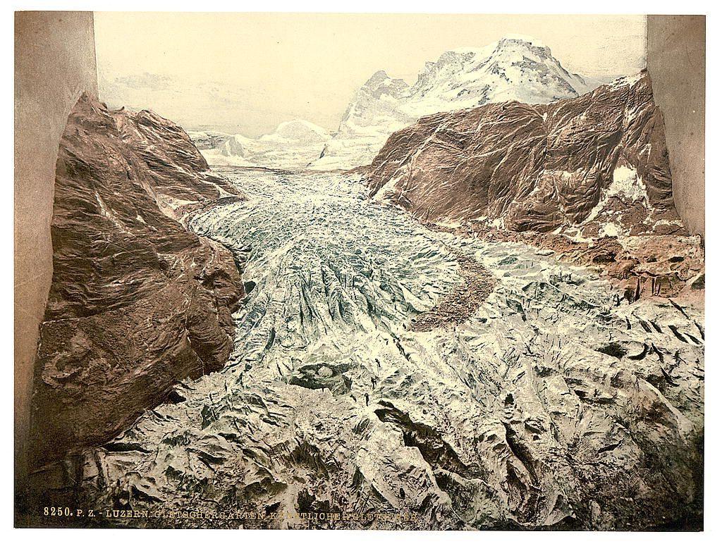 The image depicts a dramatic landscape featuring what appears to be an icy, glacier-like formation with jagged edges and deep crevasses. This artwork is presented in two frames against a plain background, which gives the impression of looking through an opening or portal into another world. The colors are muted earth tones, primarily shades of brown and gray, suggesting either age or artistic choice to convey a cold atmosphere.

Intricate details highlight the textures within the glacier-like formation, with fine lines depicting cracks and crevices that resemble natural ice formations found in glacial environments. Behind this foreground scene, more rugged mountainous terrain extends into the distance under a pale sky, hinting at an expansive wilderness beyond.

The image is labeled "8250 P.Z." followed by text indicating it's from Lucerne (Zürichtal) and possibly related to a glacier or glacial formation in Switzerland. The date range of ca. 1890-1900 suggests that this photochrom print may have been produced during the late 19th century, aligning with periods when such techniques were popular for creating artistic reproductions from original photographs.

The overall composition conveys a sense of awe and grandeur associated with natural landscapes, potentially evoking themes related to exploration or the sublime in nature.