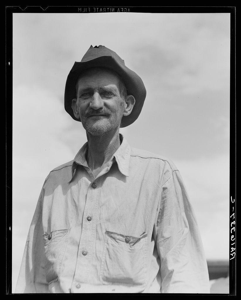 A black and white portrait of a middle-aged man wearing a wide-brimmed hat. He appears to be an older farmer, as indicated by the text at the bottom left corner which reads "Ex-tenant farmer on relief grant in Imperial Valley, California". The photograph is marked with the date "FEB 1947", suggesting it was taken during or after World War II when many people were struggling financially.
