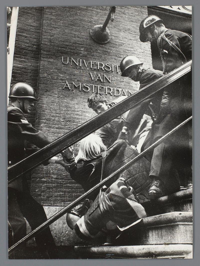 The image is a black and white photograph depicting an intense moment at what appears to be the entrance of "Universiteit van Amsterdam," as indicated by the signage on the brick wall. Multiple individuals are engaged in physical interaction; some wear helmets, suggesting they may be police or security forces. One person is being physically restrained against the railing leading up to a building door, while others assist and observe. The scene conveys tension and urgency.

The photograph carries historical significance as it was taken during "Ontruiming van het bezette Maagdenhuis," an event that occurred in Amsterdam on May 13-14, 1968. It is attributed to Ed van der Elsken, a renowned Dutch street photographer known for capturing the social dynamics and cultural shifts of his time.

The image captures not only the physical struggle but also hints at underlying political or social issues that were prevalent during this period in Amsterdam's history.