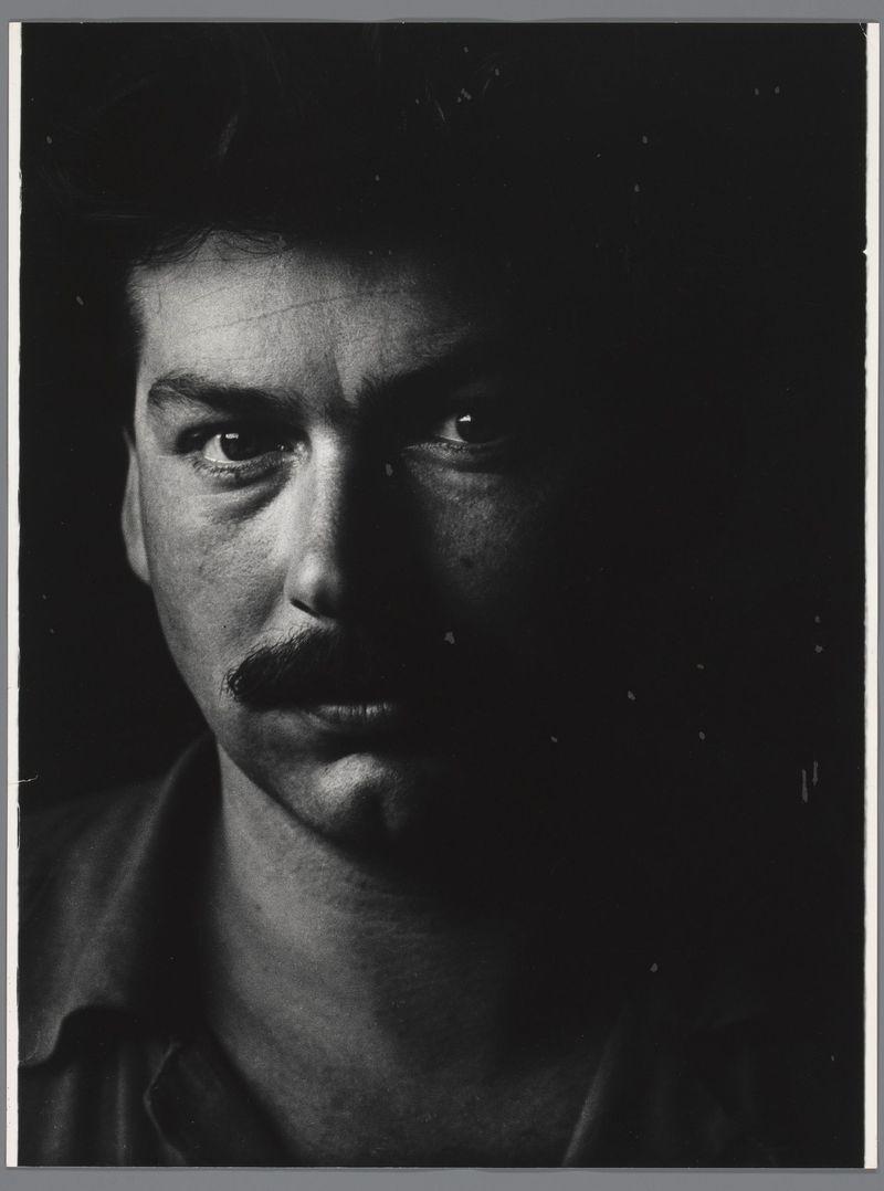 The image is a black and white portrait of a man, presumably from the mid-20th century based on its style. It features dramatic lighting that highlights his intense gaze directly at the camera, creating strong contrasts between light and shadow across his face. The man has prominent eyebrows, dark eyes with reflective pupils, a mustache, and is wearing what appears to be a collared shirt or jacket. His expression conveys determination or intensity.

The background is completely black, which accentuates the subject's features even more so. There are no discernible objects in the immediate vicinity that give away his profession or environment; it seems like a studio portrait focused on capturing an emotional essence rather than detailed realism. The image evokes a sense of intimacy and directness from its composition.

There is additional information about this photo: Portret van Karel Appel, Ed van der Elsken (1952 - 1953), which indicates that the portrait may be associated with artist Karel Appel or photographer Ed van der Elsken.