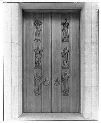 The image displays a black and white photograph of an ornate door with two large panels, each adorned with metal relief figures. The top left panel features the word "HORY" accompanied by four figures that appear to be engaged in various activities such as playing musical instruments or reading books. Opposite it on the right is another figure labeled "TUR," depicted standing and holding what appears to represent a scroll or document.

Below, centered between two handles with circular knobs, are three more metal reliefs: one of a person seemingly conversing with another while writing in an open book; below them hangs a small round object. The door has significant wear around the edges where it meets its frame and shows some discoloration on the wood's surface.

This image is cataloged as part of Library of Congress (John Adams Building) Figures on metal door (west entrance), with historical context that suggests these doors were created in roughly 1920 to 1950. The artist associated with this work, listed under "Horydczak," likely refers to the person who designed or executed these engravings and is estimated to have been active between approximately 1890-1971.

The photograph itself measures about eight by ten inches on a safety negative film basis. The specific reference number provided for this image suggests that it may be part of an archival collection, potentially i [...]