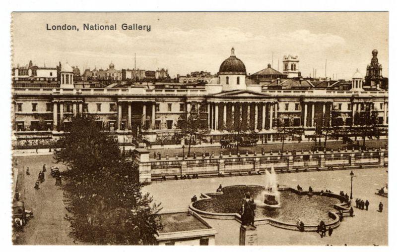 The image depicts a historic black and white photograph of the National Gallery in London. The building features classical architecture with prominent columns, large windows, and a dome at one end. In front of the gallery is an expansive plaza or courtyard where people are seen walking around; some appear to be standing near a fountain that's spouting water into a circular basin surrounded by benches. A tree stands prominently in the foreground on the left side. The sky above appears partly cloudy, suggesting it might have been taken during fair weather conditions. No specific details about individuals or vehicles can be discerned due to the age and quality of the photo.