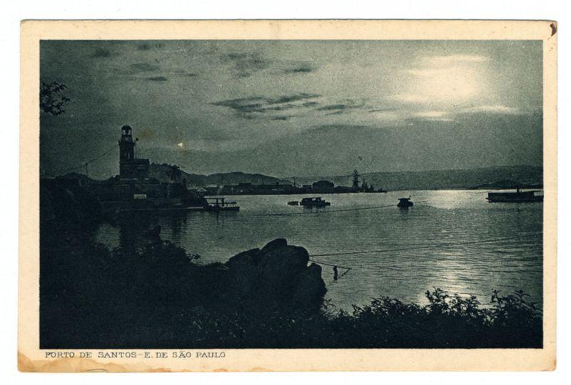 The image depicts a serene harbor scene at dusk or dawn, with muted colors that give it an atmospheric quality. In the foreground, dark rocks and vegetation suggest a shoreline perspective. The central focus is on a calm expanse of water reflecting soft light from above. Several boats are scattered across the surface; some appear to be rowboats near the shore, while others float farther away in groups.

On the left side stands an imposing clock tower with its spire reaching towards the sky, indicating it's likely part of a town or cityscape beyond the harbor limits. Behind and around this structure, faint silhouettes suggest additional buildings or structures, including what appears to be cranes, hinting at industrial activity in the vicinity.

The middle ground is dominated by more boats on water with small ripples disturbing their otherwise still reflections. In the background, a larger vessel resembling a ship or battleship can be seen anchored near another smaller structure that could possibly be a crane. The horizon line where land meets sky suggests this harbor opens to an expansive body of water.

The image is labeled "PORTO DE SANTOS E. DE SAO PAULO," indicating it's the port of Santos in São Paulo, Brazil—a historical and important maritime hub known for its trade routes with Europe during colonial times. The overall condition appears aged or vintage, perhaps dat [...]