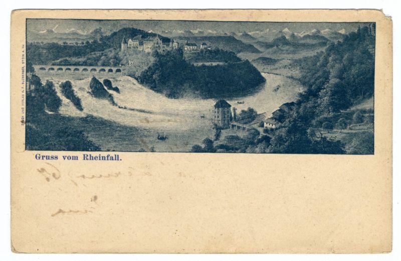 The image is a vintage postcard with an old photograph depicting the Rhine Falls. The landscape shows flowing water of the river, leading to what appears as two main falls in the distance where it meets the valley below. Surrounding this are green hills and trees indicative of forested areas or parks. A large chateau-like building on elevated ground overlooks a bridge crossing over one part of the Rhine Falls.

The top right corner shows more hilly terrain, possibly mountains further away from the falls area. This whole scene is set against a backdrop with some clouds in the sky and hints at distant hills or mountain ranges. The overall color tone is monochrome blue-grey, typical for older photographic prints.

Below this photograph on the postcard are German words "Gruss vom Rheinfall," translating to 'Greetings from Rhine Falls.' There's also faint writing near the bottom left that seems like a personal note but it's unclear and not fully legible. The card has some signs of age, such as slight discoloration and minor creasing.

This image is related to historical travel mementos or keepsakes often sent home from trips in earlier centuries before modern color photography became widespread.