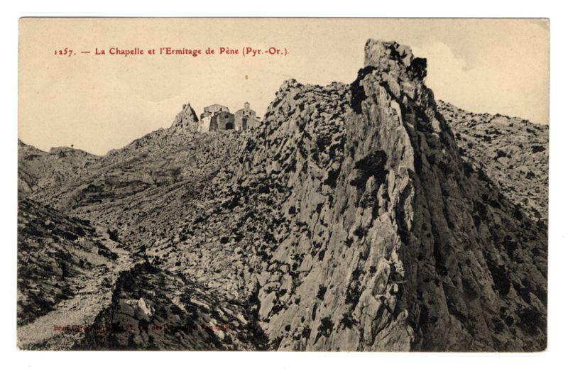 The image shows a rugged mountain landscape with rocky outcrops and sparse vegetation. In the distance, there are several old buildings or ruins nestled among the cliffs, suggesting an ancient settlement or historical site. The photo appears to be in black and white, likely taken during early photography days given its sepia tone and aged appearance.

The text at the top of the image indicates that it is a vintage postcard dated 1957 depicting "La Chapelle et l'Ermitage de Pènè" (Pyr.-Or.), which translates to The Chapel and Hermitage of Pené from the Pyrénées-Orientales region. This suggests the location is in France, specifically within the eastern part of Languedoc-Roussillon.

The bottom left corner contains a small red text that reads "Bronze Extra Fineness 1280°," which might be an indication of the quality or type of paper used for this print and its resistance to heat. Overall, the image conveys a sense of history and natural beauty associated with the Pyrénées mountains in southern France.