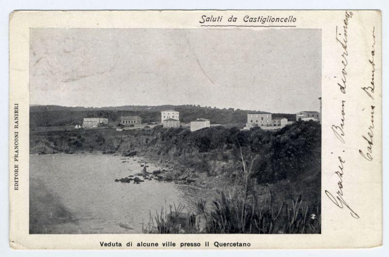 The image is a black and white postcard with handwritten annotations on the right side. It depicts a rural landscape featuring several buildings, likely residential or institutional, situated in an area that appears to be near a body of water, possibly a lake or river. The terrain around them slopes downwards towards this body of water, which has rocky shores visible along its edge.

In the foreground, there is vegetation including tall grasses and shrubs, indicative of natural flora common by such bodies of water. In one part of the image on the left side, text runs vertically with additional handwritten notes that seem to be names or annotations related to places mentioned in the printed text at the top right corner.

At the bottom center, there is a caption in Italian stating "Veduta di alcune ville presso il Quercetano," which translates to "View of some towns near Quercetano." The card also bears the name 'Saluti da Castiglione' and includes signatures that likely indicate who sent or received it.

The overall condition appears aged, with creases noticeable on the surface. There is a sense of historical context suggested by both the architectural style depicted in the image and the monochromatic quality typical of older postcards from early to mid-20th century.