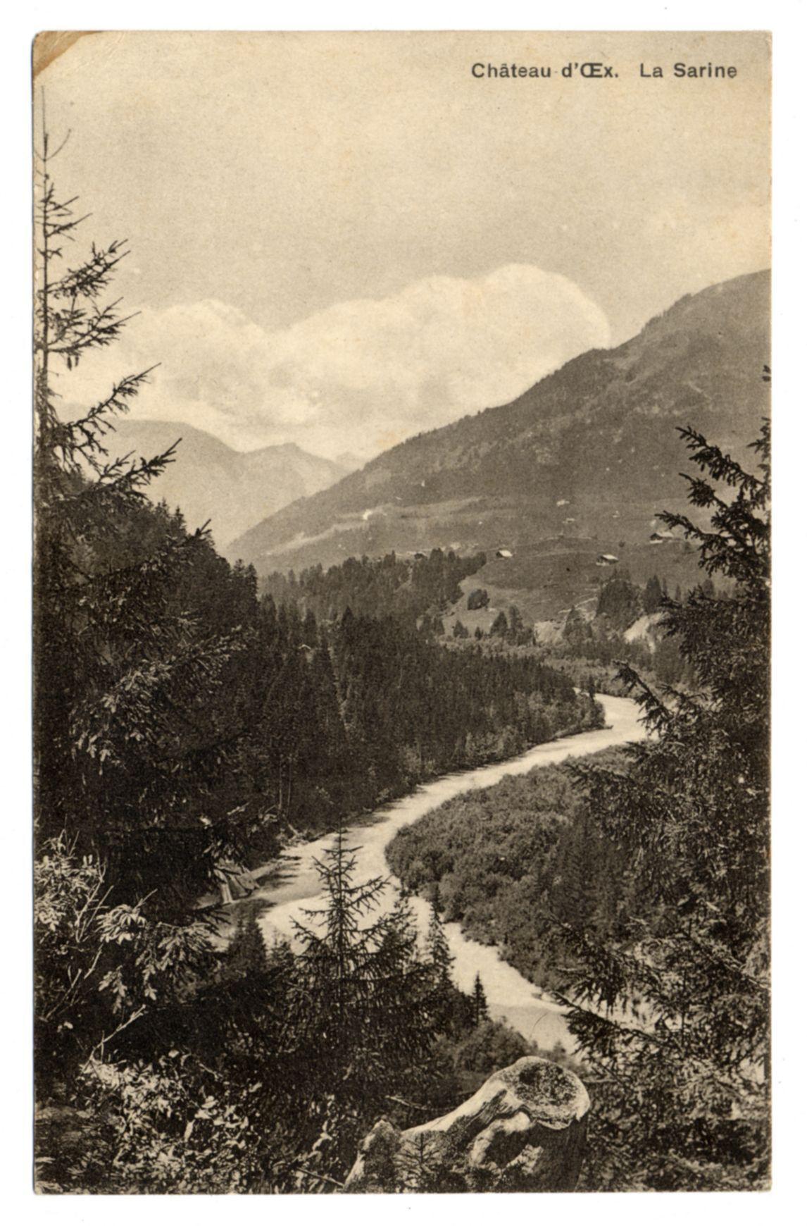 The image depicts a vintage postcard featuring an old photograph of the La Sarine River meandering through a forested mountain landscape. The river, with its winding path and rocky banks, is flanked by dense trees primarily in shades of grey that indicate it's likely a sepia-toned or monochromatic print. In the background, rolling hills rise to form mountains partially shrouded in mist, creating an atmospheric scene reminiscent of early 20th-century European countryside imagery.

The top left corner contains text "Château d'Ex." indicating this may be near or within a region associated with that name. The bottom right reads "La Sarine," likely the river's name being featured on the postcard as its subject matter is centered around it. There are no visible people, animals, modern structures, or other indications of contemporary life in the scene.

The overall composition suggests this image may have been taken during a time when photography was less common and often used to preserve memories of picturesque landscapes for personal keepsakes or communication purposes among distant friends and family members before widespread availability of postcards.