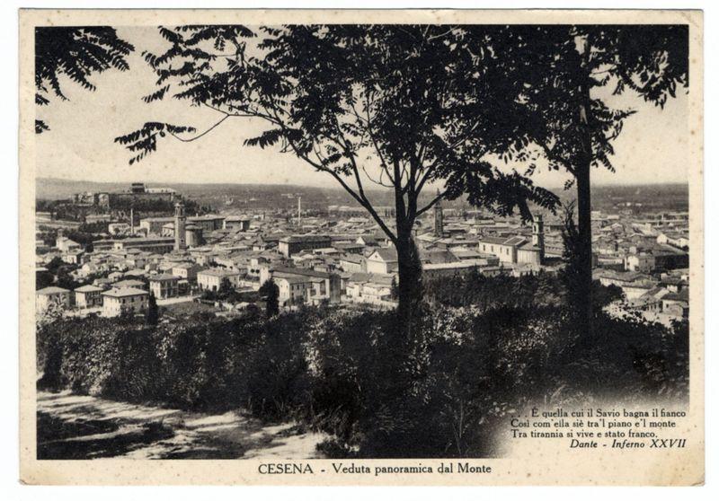 The image is a black and white vintage postcard depicting an expansive view of the cityscape in Cesena, Italy. The photograph captures the town from above on what appears to be Monte (Mount) Dante, as indicated by the text at the bottom right corner which mentions "Dante - Inferno XXVII." This suggests that the vantage point is likely near or within a part of Mount Dante.

Two prominent trees frame the top edges of the photograph, with their branches extending into and over some leaves from the left tree. The architecture below consists of numerous buildings closely packed together, featuring various styles including residential houses, churches, and larger structures possibly indicative of town halls or public institutions. Some taller spires are visible among the lower rooftops.

The sky is clear in this image, indicating a sunny day with no signs of clouds obstructing the view. The overall composition suggests that Cesena's landscape has evolved significantly since the photo was