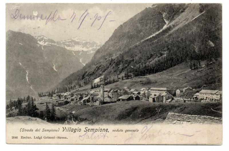 The image is a vintage postcard depicting the mountainous region of Villaggio Semione, specifically Strada del Sempione. It appears to be an old photograph with handwritten annotations and signatures on it. The scene shows a small village nestled in a valley surrounded by rugged mountains with sparse tree coverage. In the foreground, there's visible snowfall or perhaps frost covering patches of ground, indicating cold weather conditions typical for mountainous areas.

The postcard is marked "2046 Esclusiul Luigi Grisoni - Stresa," which suggests it was created in 1938 by photographer Luigi Grisoni from the town of Stresa. Handwritten inscriptions on the top left corner and bottom right seem to be personal notes, possibly signatures or annotations made after the postcard's creation.

The detailed description provided includes information about the origin of the photo, indicating it is sourced from a larger collection likely related to photography in Italy during that era. The overall setting suggests an early 20th-century depiction of rural life and landscape architecture within this Italian mountainous community.