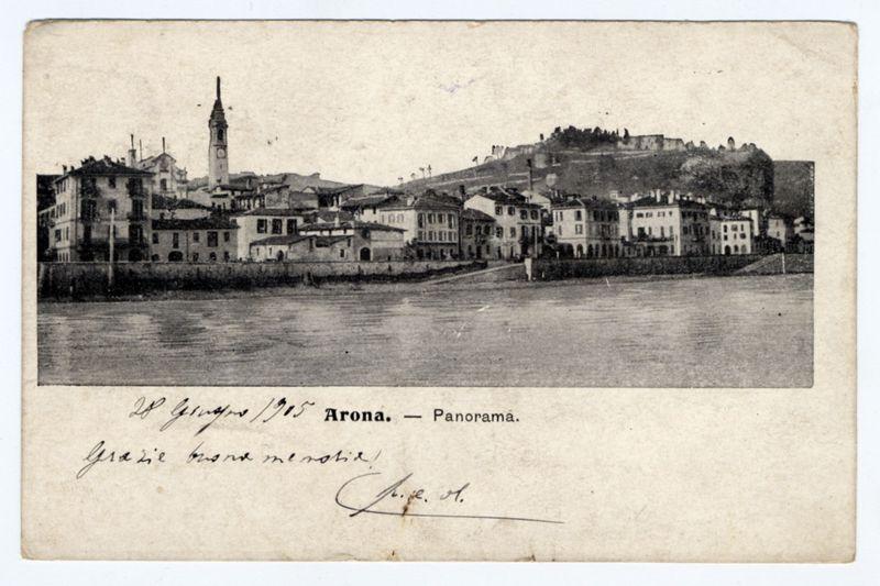 The image depicts a vintage panoramic view of the town Arona, situated on Lago Maggiore in Italy. A notable feature is the prominent bell tower with clocks marking time for both Roman and 24-hour systems. The landscape includes historical architecture typical of European towns from this period, showcasing buildings closely packed together along the lakefront. In the background, a fortified hilltop hints at Arona's medieval past or strategic military significance. The water reflects the light in an almost mirror-like manner, indicating it might be taken during midday when sunlight is optimal for such reflections.

Inscribed on the photograph are "Arona - Panorama," suggesting that this image represents one of several panoramic views available to capture the entirety and various aspects of Arona's town. The signature at the bottom right could indicate a photographer or an owner who signed it, possibly commemorating their visit with a personal note: "28 Giugno 1905 Arona - Panorama." Th