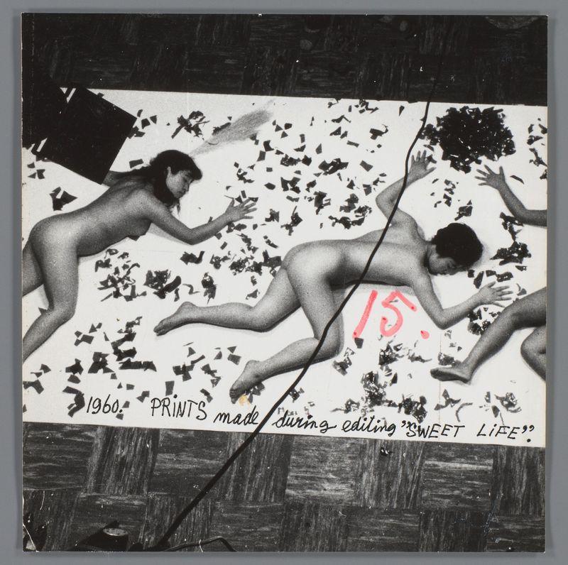 The image depicts two nude figures in motion on a surface scattered with small, irregularly shaped pieces that resemble fragments of paper or confetti. The figure on the left appears to be sliding into position while reaching out towards something outside of view, possibly another person or an object not shown in this frame. This individual's posture is dynamic and suggests movement.

The second figure, located slightly above and behind the first one, has a more sprawled pose with limbs extended outward as if they were leaping from their current location. Both figures cast elongated shadows on the surface beneath them.

Overlaid text includes "15," which could indicate age or rank; "1960s"; "PRINTS made during editing 'Sweet Life'." The writing style and placement give a sense of immediacy, as if captured in real-time. Additional handwritten elements like red markings and the phrase "sweet life" add an informal, candid quality to the image.

The overall composition evokes themes 
