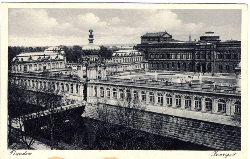 This black and white photograph depicts a historical European palace complex. The main structure features classical architectural elements such as columns, arches, and intricate facades with large windows. Notable is the presence of an elevated circular dome-like building in the center, surrounded by rectangular wings with uniform window patterns. A bridge connects two sections of this sprawling estate over what appears to be a moat or canal. Trees are visible along the banks beside which runs another stone embankment parallel to the waterway.

The sky is cloudy and suggests an outdoor setting during daylight hours without any direct sunlight, indicative of either overcast weather or shadowed architecture features obscuring bright light sources like windows or openings on facades. The image bears inscriptions at its bottom reading 'Dresden' with additional text that seems too small to read clearly but includes a word ending in '-inger,' which might refer to the photographer's name, L