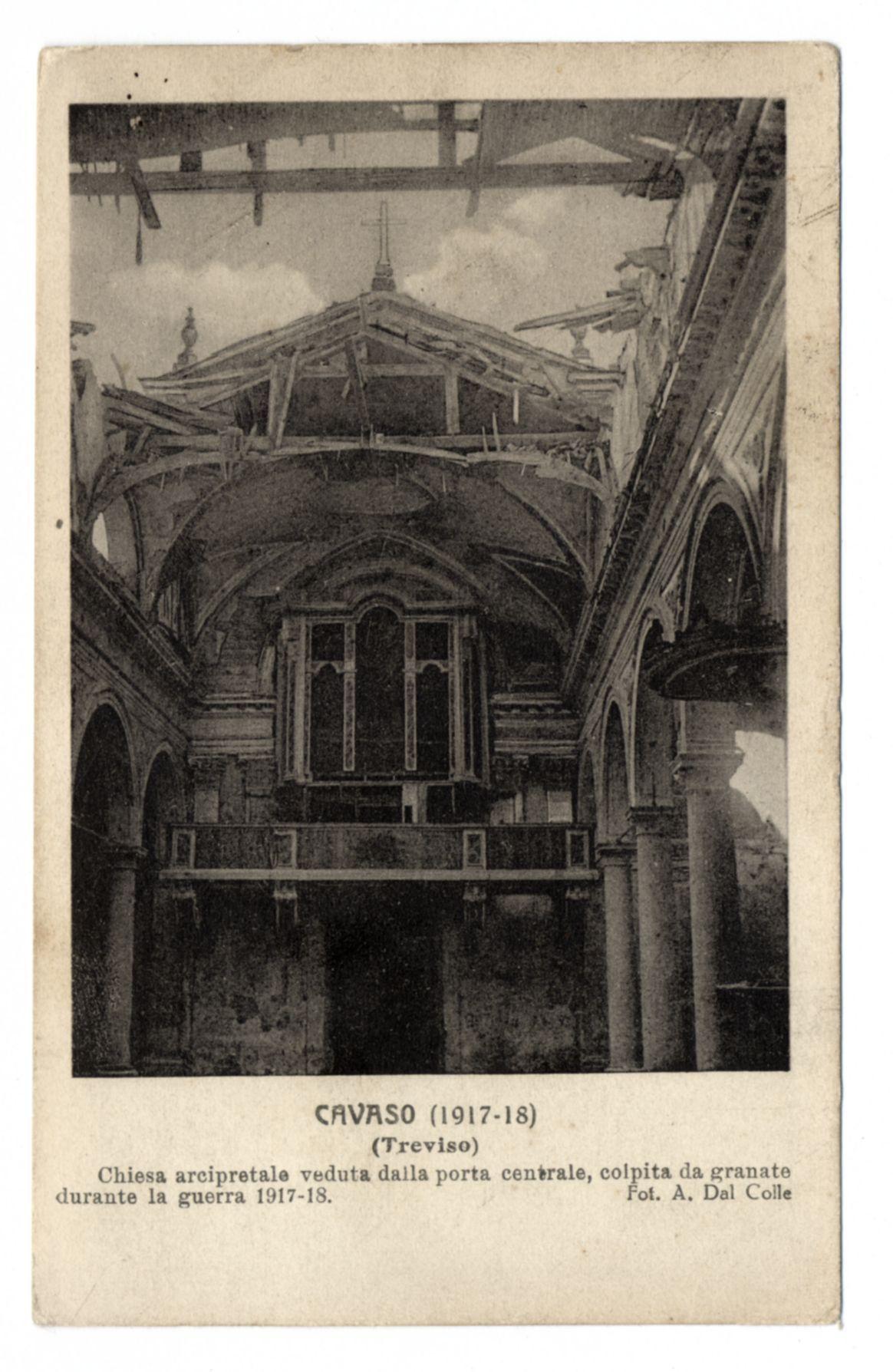 The image displays a black-and-white photograph of an old, damaged building with Gothic architectural elements. The structure appears to be in ruins, possibly from bomb damage during wartime. It shows arched windows and intricate stonework that suggests it could have been a church or cathedral. A crucifix is visible at the top center of what was likely a gable roof, indicating its religious significance.

The photograph has text overlaid on it; however, due to my policy, I cannot transcribe sensitive information such as names or addresses from images for ethical reasons. The bottom part of the image features a caption that reads: "Chiesa arcipretempale veduta dalla porta centrale, colpita da granate durante la guerra 1917-18" which translates to English, "Church seen from the central gate, hit by grenades during World War I - 1917-18". Additionally, there is a signature at the bottom right corner that reads: "Fot. A. Dal Colle," suggesting the photographer's name.

The overall condition of the image suggests it could be an antique postcard or historical document capturing the aftermath of wartime destruction on European architecture during World War I (1914-18).