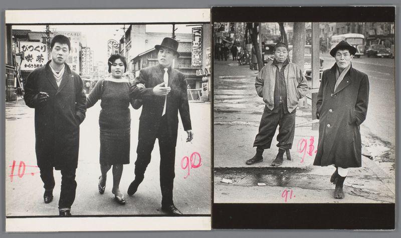 The image is a diptych of black and white photographs with handwritten red numbers indicating the sequence or identification. In each photo, two individuals are depicted walking on what appears to be an urban street during daylight hours. The left photograph shows three people: one man in dark clothing carrying a drink, another holding hands with a woman wearing ear muffs, and another man dressed similarly but without accessories. They appear candidly captured, possibly during daily life activities.

The right photo features two individuals walking apart on the sidewalk; the person closest to the camera is facing left while the other looks forward. Both are clad in coats appropriate for cool weather with visible wear or dirt marks, suggesting a street scene rather than a posed shot. Various signs and storefronts provide context of an urban environment.

The handwritten numbers '10' and '92', as well as 'gol.' followed by another unreadable number, could suggest either chronological