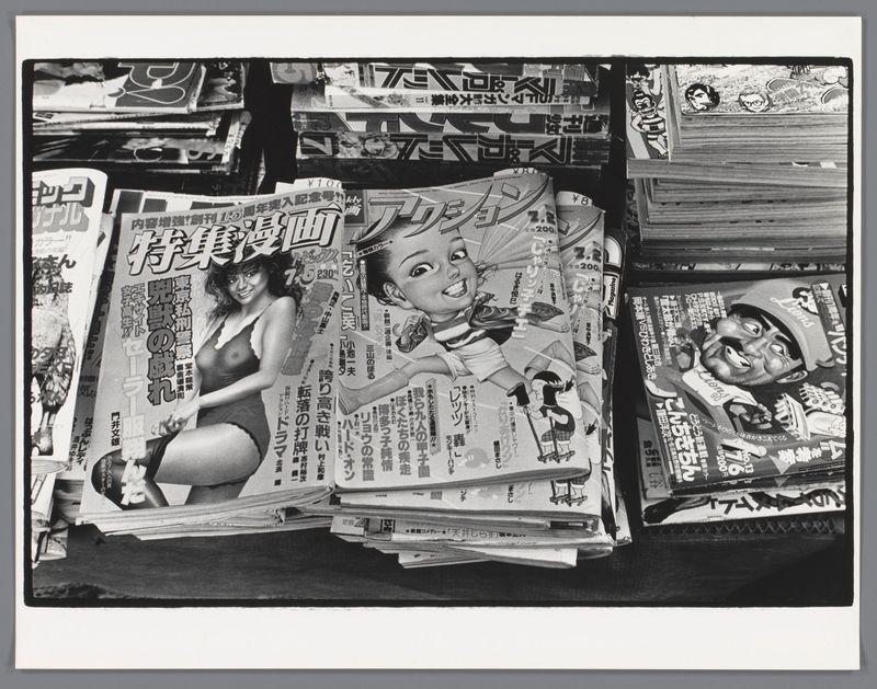 The image is a black and white photograph depicting an assortment of Japanese comic books, magazines, or "manga," spread out on a surface. The comics feature various characters in different poses and expressions, with some panels showing text as well. Some of the visible titles include names such as "Tenchou Hattori" (探偵刑事ハットウリ), which suggests these are crime fiction manga featuring Detective Chief Tenchou Hattori.

The comic books appear to be stacked haphazardly on top of each other, creating a sense of disarray. The layout and the way they are piled suggest that this could have been captured during or after someone was browsing through them. Given their variety in style and content, it seems like an eclectic mix catering to different tastes within manga culture.

This photograph by Ed van der Elsken likely aims to capture a slice of Japanese pop culture from around 1982 when the image is believed to have been taken based on its inclusion in the "Rotease Japanse tijdschriften" collection. It reflects both the popularity and ubiquity of manga as well as possibly hinting at the social aspect of reading comics, which could be a communal or individual activity during that era.

The image's composition with multiple layers of comic books provides depth to the scene, emphasizing their thickness and abundance. The text on the covers is in Japanese characters (kanji), indicati [...]