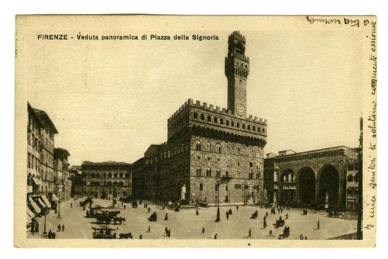 The image is a sepia-toned postcard showing a panoramic view of Piazza della Signoria in Florence, Italy. The iconic Palazzo Vecchio with its large clock tower dominates the center and background of the scene. In front of the palazzo stands an archway leading to Via San Gallo on one side and via Tornabuoni on the other.

The piazza is bustling with life; people are walking around, some sitting at outdoor cafes or resting near a fountain that appears in the lower left corner of the image. The architecture surrounding Piazza della Signoria features historical buildings typical for Florence's Renaissance era.

On top right and bottom right corners, handwritten notations possibly indicate ownership or personal notes, though they're partially obscured by creases on the postcard itself. A small inscription at the top reads "FIRENZE - Veduta panoramica di Piazza della Signoria." The overall atmosphere conveys a sense of historical richness combined with vibrant everyday life in Florence d