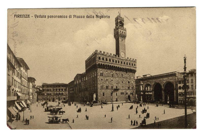 The image is a sepia-toned postcard showing an historical European cityscape. Prominently featured in the center is Palazzo della Signoria, also known as the Palazzo Vecchio, with its imposing architecture and large clock tower rising above it. The square below, Piazza della Signoria, is bustling with activity; individuals are scattered throughout, some strolling while others sit on benches or ledges of nearby buildings. A few horse-drawn carriages add a touch of historical transport mode to the scene.

The photograph captures late 19th-century urban life in Florence, Italy, as indicated by architectural details like large arches and classical statues adorning the square's edge. The sky is overcast with light cloud cover, which diffuses shadows on the ground below.

Intricate script at the top of the image reads "FIRENZE - Veduta panoramica di Piazza della Signoria," suggesting that this postcard documents a panoramic view of Florence’s renowned square known as Palazzo della Signor