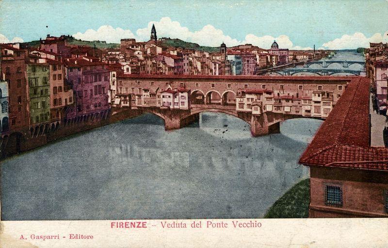 The image is a vintage postcard featuring the famous Ponte Vecchio bridge in Florence, Italy. The perspective shows an elevated view of the river Arno flowing beneath the old stone arches and buildings on both sides. The architecture along the riverside displays diverse colors like reds, pinks, greens, and oranges with varying styles indicative of different periods or owners. Notable features include a prominent church spire in the distance atop a hill, adding to the scenic panorama typical for Florence's skyline. This postcard appears aged with some discoloration that suggests it has been handled multiple times over decades. The text at the bottom indicates "Firenze - Veduta del Ponte Vecchio," translating from Italian as "Florence - View of the Old Bridge." It also credits 'A. Gasparri' who may be an editor or publisher associated with this work, and includes a website link for further information which is not fully visible in this image snippet.