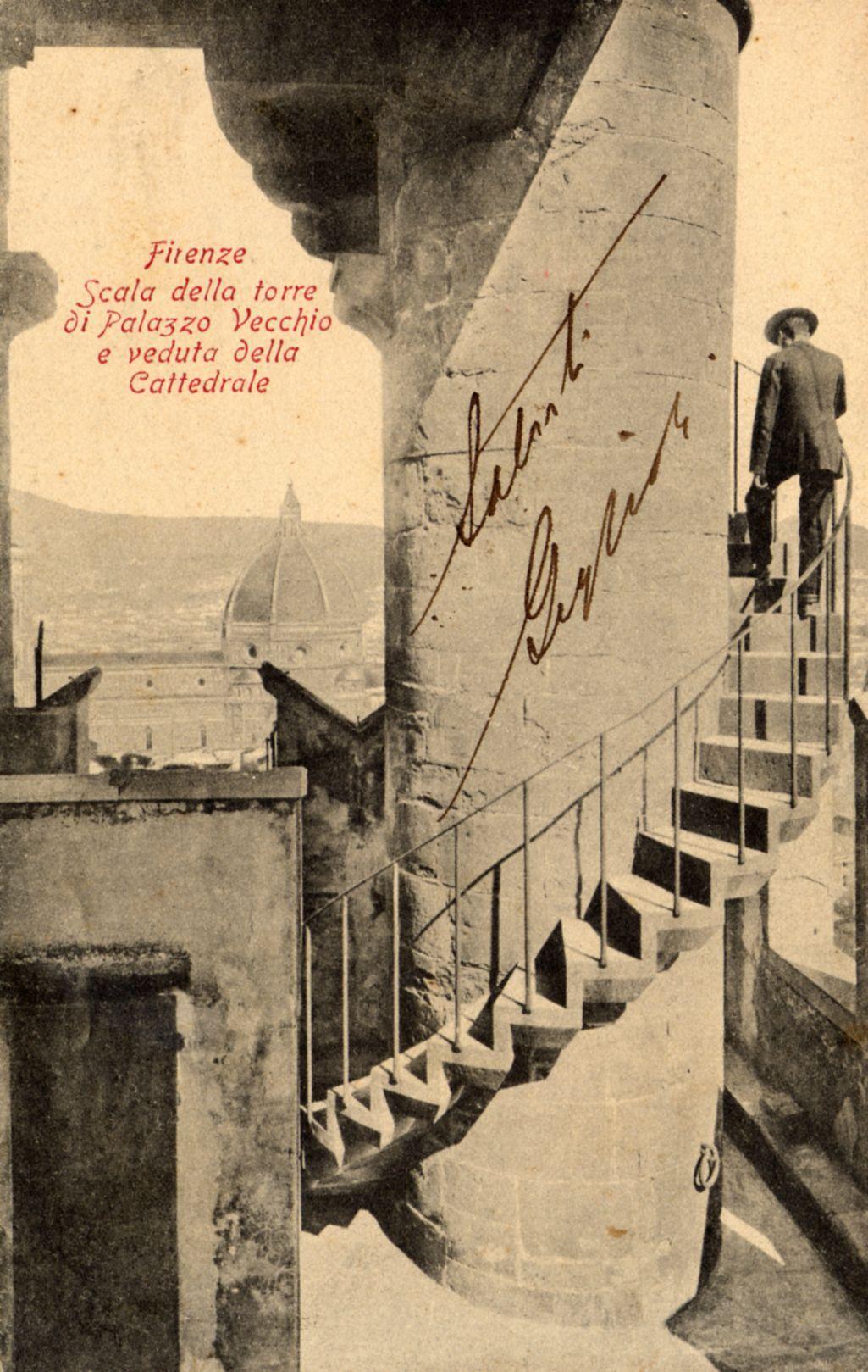 The image shows a vintage photograph of an individual ascending a spiral staircase within what appears to be the historic Palazzo Vecchio in Florence, Italy. The person is dressed formally and seems contemplative as they look out over the cityscape from atop the structure. Visible through the stairwell opening are iconic landmarks such as Giotto's Bell Tower (Torre di Campanile) and the dome of Santa Maria del Fiore, known locally as Il Duomo or simply "the Dome." The photograph is tinged with a sepia tone that suggests it could be from an early 20th-century album. Overlaid in red text at the top left corner are words indicating the location: "Firenze" (Florence), followed by references to specific viewpoints ("Scala della torre di Palazzo Vecchio e vedere della Cattedrale"), which translate as "The tower staircase of Palazzo Vecchio and view of the Cathedral." A signature, presumably that of the photographer or author, is visible on a pillar in cursive. The setting evokes a sense of h