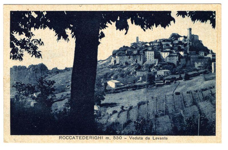 The image shows a vintage postcard featuring an old hillside village with buildings densely packed on the slope. A prominent tree stands in the foreground, silhouetted against the lighter background of the town and sky. The name "ROCCATEDERIGHI m. 550" is printed at the bottom left corner along with a description that translates to "North View from Levante." In smaller text below this are additional Italian words indicating elevation ("m. 550") or possibly suggesting the vantage point of view (veduta da levante). The overall colors and quality suggest an early photograph, likely from the late 19th century given its style and monochromatic tones. There's a textured appearance to the paper that adds historical authenticity.
