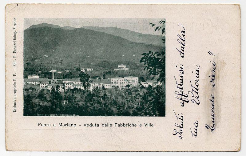 The image is a vintage postcard with handwritten Italian text on the right side and printed labels at the bottom. The main focus of the card shows an old photograph depicting a view from above, possibly within or overlooking industrial areas such as factories (Fabbriche) and towns (Ville). In the background are hilly landscapes under a cloudy sky.

The postcard is slightly faded with creases indicating age, suggesting it might have been in circulation for some time. The handwriting appears to be personal notes, likely adding context or sentimental value related to the image on the card. At the bottom of the printed labels, "Ponte a Moriano - Veduta delle Fabbriche e Ville" is written, which translates from Italian as “View from Ponte a Moriano – Factories and Towns.”

The overall condition appears worn but preserved enough for legibility despite its age.