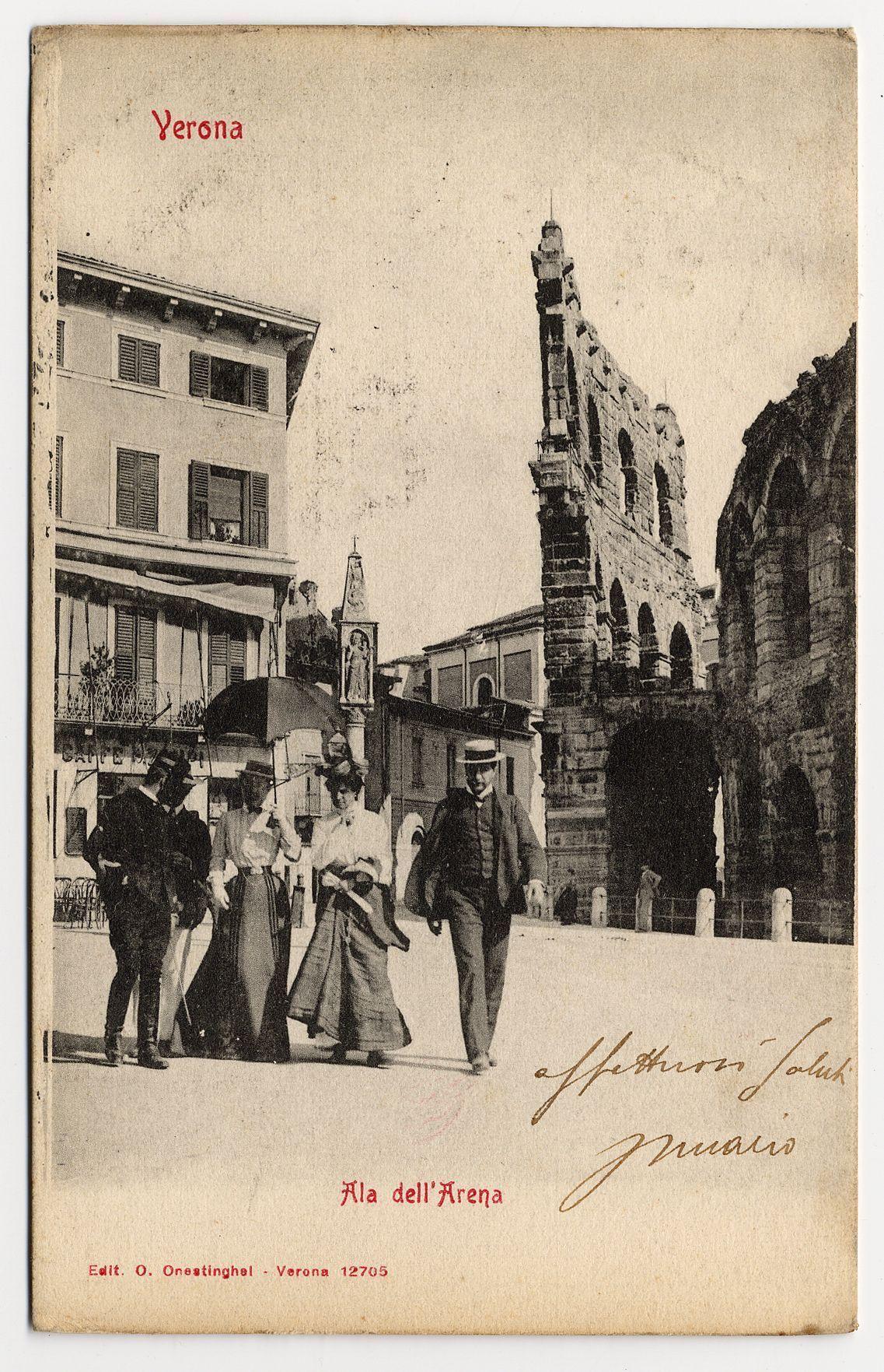 The image is a vintage postcard featuring a black and white photograph. At the top, in red text on a beige background, it reads "Verona." Below this heading is an old street scene with several individuals walking along what appears to be a pedestrian zone or plaza. The people are dressed in early 20th-century fashion; men wear suits with hats while women don long dresses and high collars.

To the right of the image stands the ruins of Roman structures, likely part of Verona's ancient architecture including parts of an amphitheater known as "Arena." These buildings have a historical look, featuring arches and weathered stone. A handwritten inscription in cursive script adorns the top-right corner with additional text possibly indicating ownership or personal notes.

In red on the bottom right is another caption: "Ala dell' Arena" which translates to 'The Wing of the Arena'. The card's publisher information reads "Edit. O. Onestighei - Verona 12705." Additionally, there seems to be a